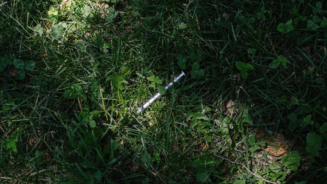 A discarded heroin needle lays in McPherson Square Park, next to the library.