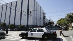 A San Francisco police car blocks a roadway outside a UPS package delivery warehouse where a shooting took place Wednesday, June 14, 2017, in San Francisco. A UPS spokesman says four people were injured in the shooting at the facility and that the shooter was an employee. (AP Photo/Eric Risberg)