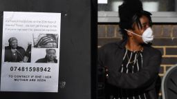 LONDON, ENGLAND - JUNE 14:  A missing person poster is displayed on a parking meter as a young girl with a face mask looks on near 24 storey residential Grenfell Tower block in Latimer Road, West London on June 14, 2017 in London, England.  The Mayor of London, Sadiq Khan, has declared the fire a major incident as more than 200 firefighters are still tackling the blaze, while at least 50 people are receiving hospital treatment.  (Photo by Chris J Ratcliffe/Getty Images)