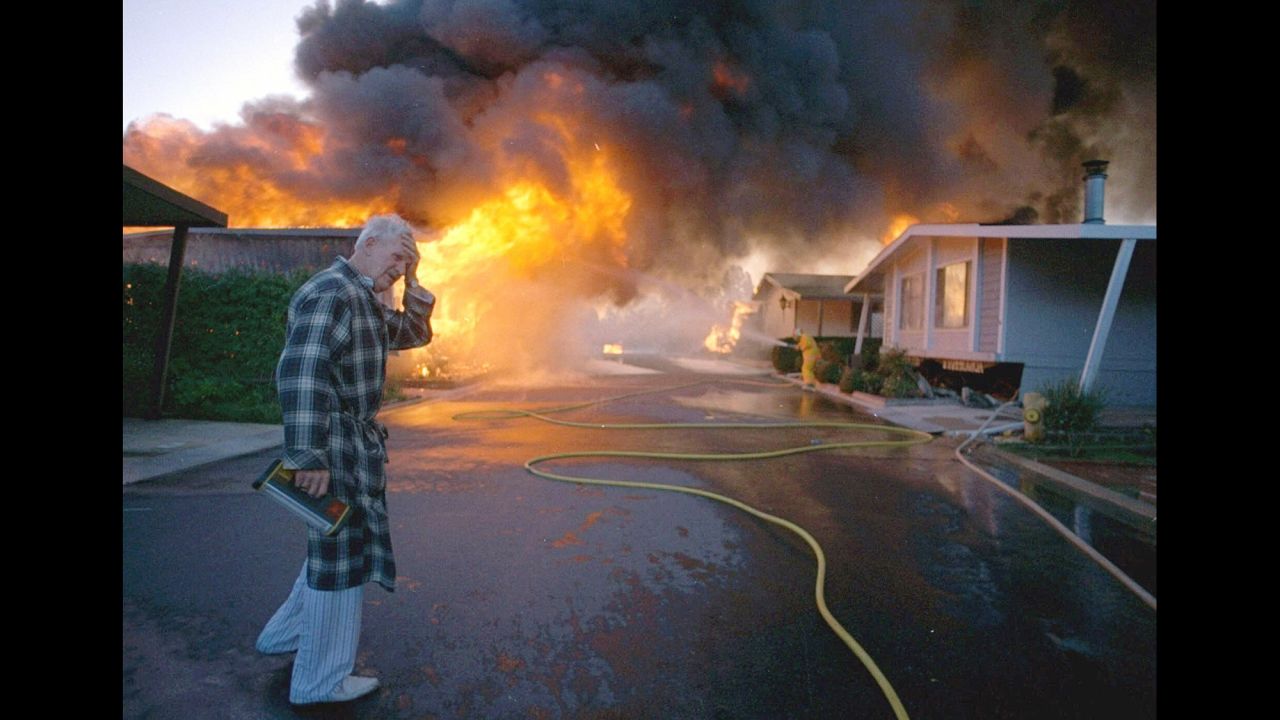 In the early morning hours of January 17, 1994, the 6.7 magnitude Northridge earthquake rattled the San Fernando Valley of Los Angeles, smashing buildings, toppling interstate highways and leading to at least 57 deaths. In this photo, Ray Hudson mourns the loss of a friend's home, shown engulfed in flames sparked by the earthquake. The quake was the costliest in US history, with damages topping $20 billion.