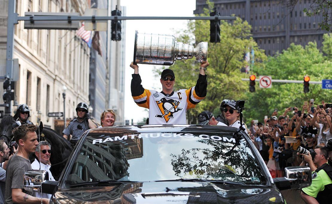 The Penguins' Sidney Crosby hoists the Stanley Cup during a victory parade in Pittsburgh.