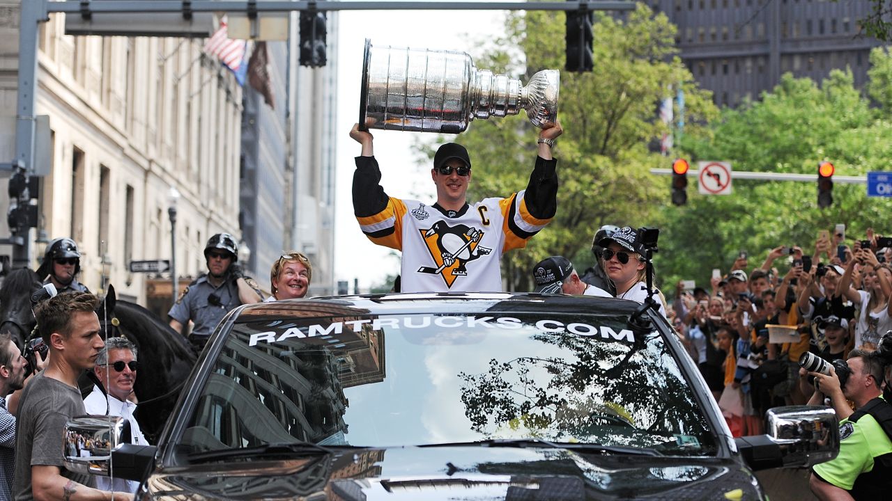 The Penguins' Sidney Crosby hoists the Stanley Cup during a victory parade in Pittsburgh.
