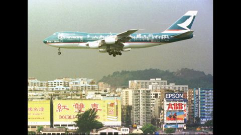A Cathay Pacific Boeing-747 jet flies over residential buildings near Hong Kong's Kai Tak airport, on June 19, 1997.