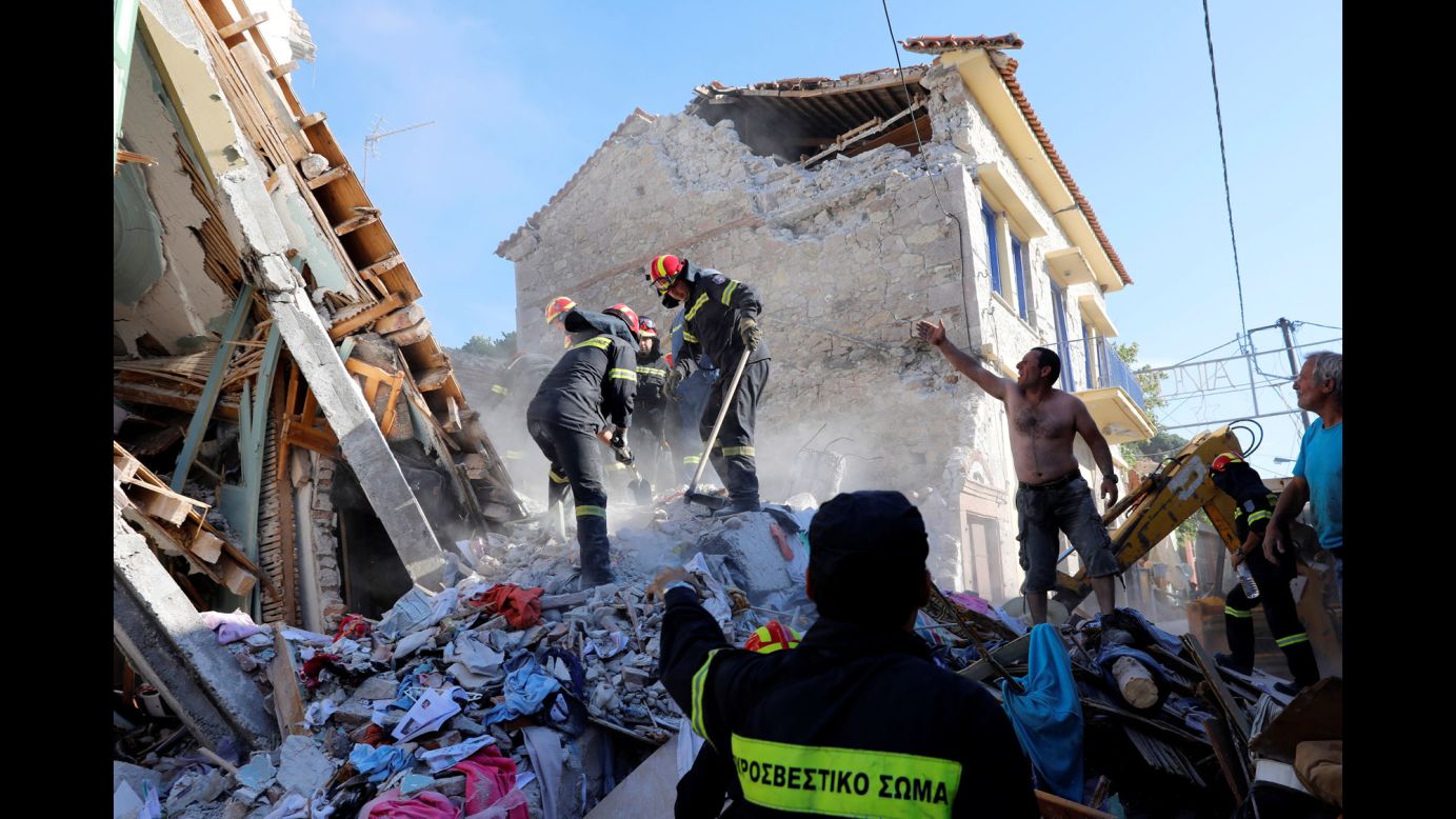 Rescuers search for victims at a collapsed building in Vrisa, Greece, after a strong earthquake shook the eastern Aegean Sea on Monday, June 12.