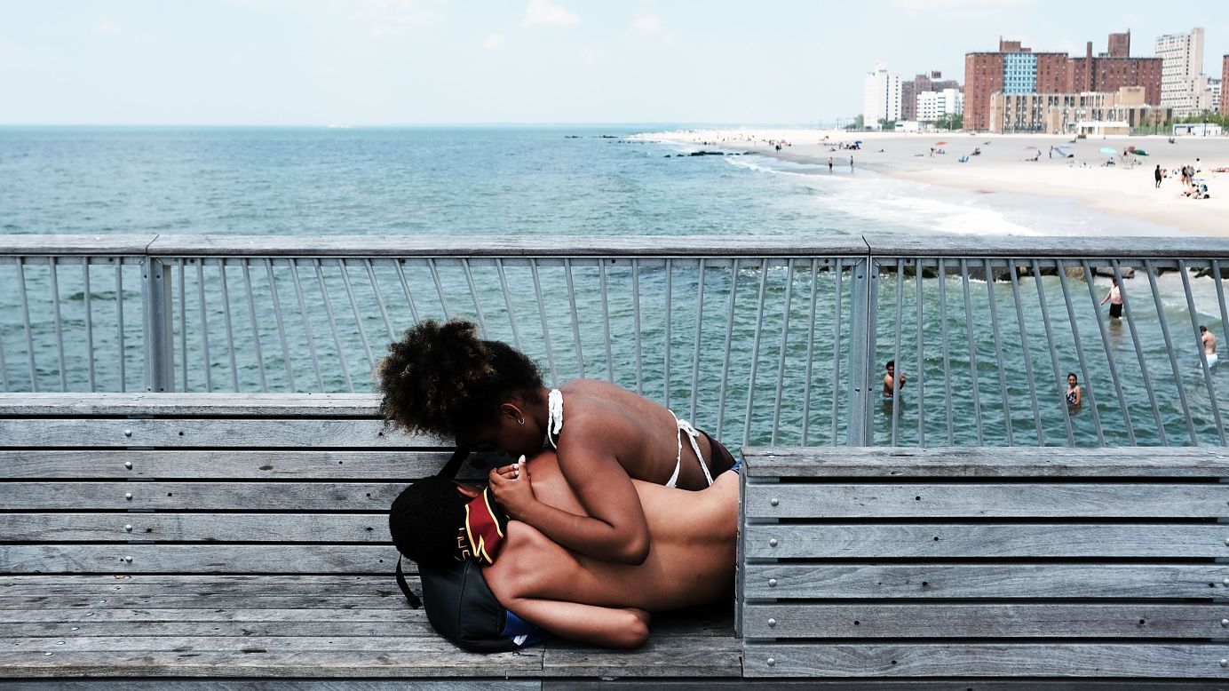 Teenagers relax on the Coney Island boardwalk Tuesday, June 13, in New York.