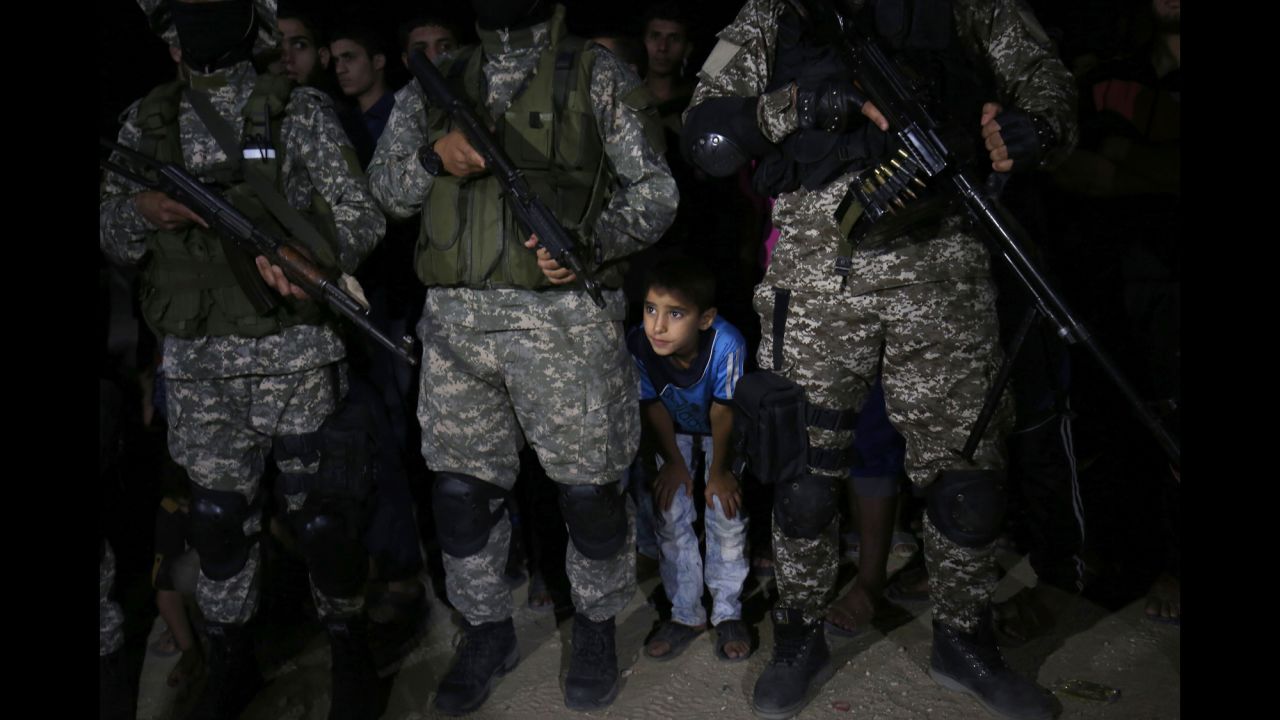 A child is seen with fighters from the Ezzedine al-Qassam Brigades, the armed wing of the Palestinian movement Hamas, during a memorial service in Gaza for leader Ibrahim Abu al-Naja on Saturday, June 10. Al-Naja was killed in an accidental explosion earlier this month, the group said.