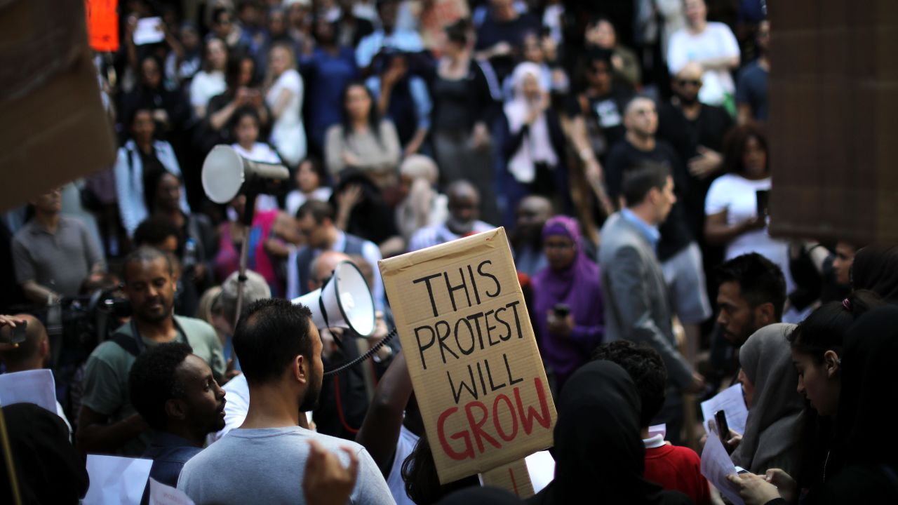 LONDON, ENGLAND - JUNE 16: Protesters gather outside of Kensington Town Hall on June 16, 2017 in London, England. 30 people have been confirmed dead and dozens still missing after the 24 storey residential Grenfell Tower block in Latimer Road was engulfed in flames in the early hours of June 14. Emergency services will spend a third day searching through the building for bodies. Police have said that some victims may never be identified. (Photo by Dan Kitwood/Getty Images)