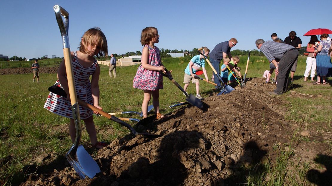 Children playfully shovel the dirt after a groundbreaking ceremony for the new Countryside Community Church earlier this month.
