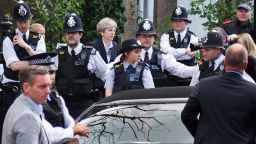 Prime Minister Theresa May leaves St Clements Church with heavy police protection as angry Grenfell Tower protesters try to surround her car on Saturday, June 16 in London. 