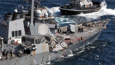 With the help of tug boats, the USS Fitzgerald, with its damaged starboard side, makes its way toward the US Navel base, Yokosuka, after colliding with a Philippines based container ship off the coast of Shimoda, Japan on June 17. Seven U.S. Navy crew members are missing and three, including captain, were injured.