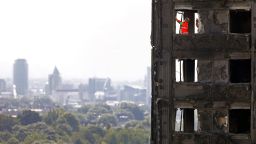 Members of the emergency services work on the top floor of the charred remains of the Grenfell Tower block in Kensington, west London, on June 17.