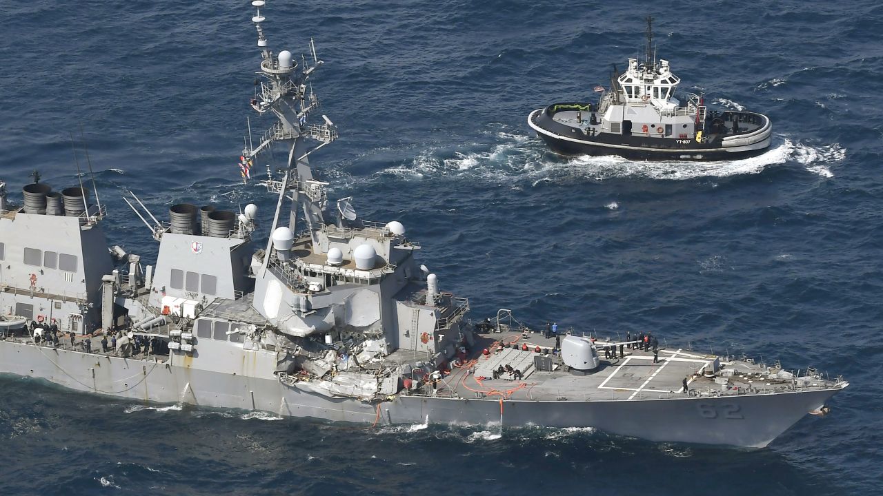 The USS Fitzgerald heads to Yokosuka, home base of the 7th Fleet, beside a US tugboat, off Shimoda, Japan on Saturday.