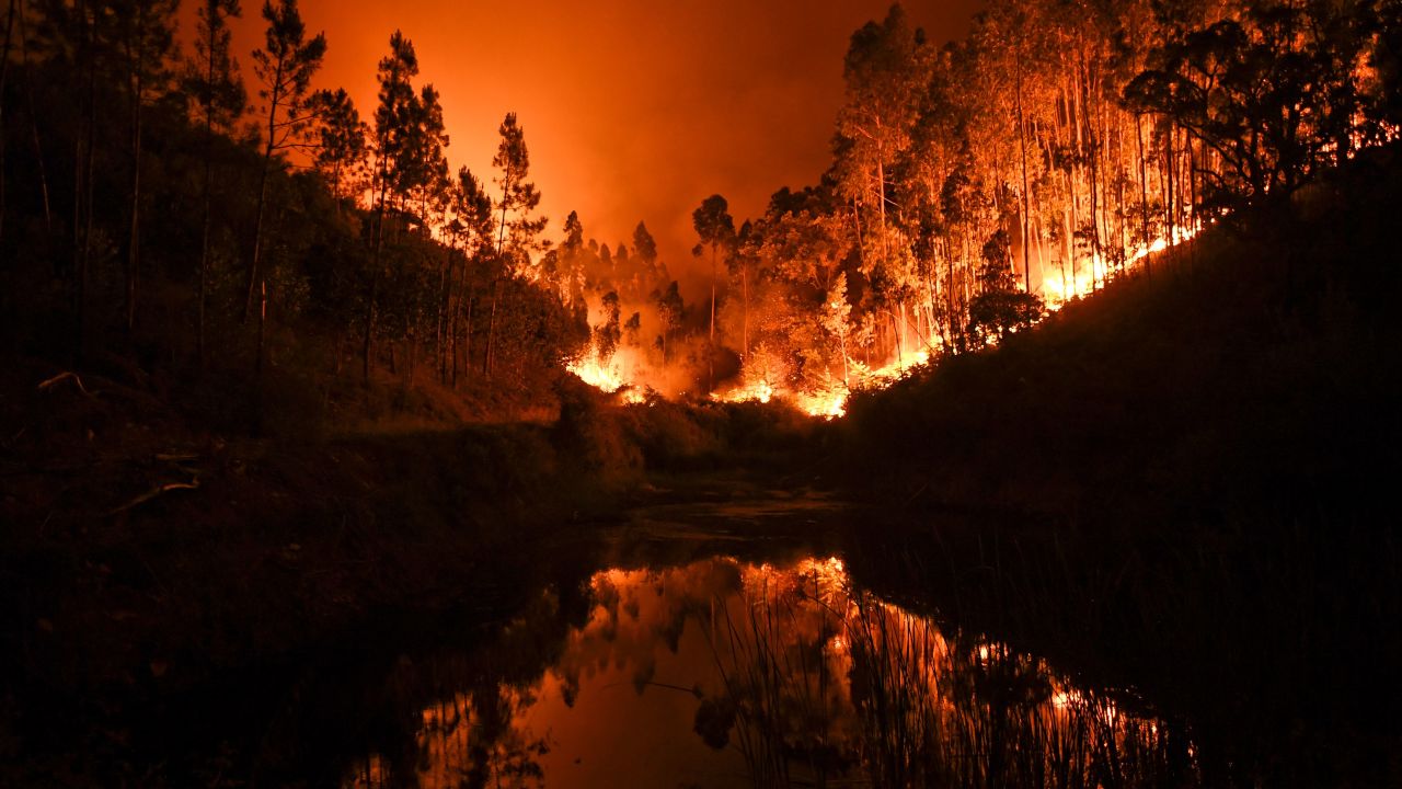A wildfire is reflected in a stream at Penela, Coimbra, central Portugal, on June 18, 2017. 
A wildfire in central Portugal killed at least 25 people and injured 16 others, most of them burning to death in their cars, the government said on June 18, 2017. Several hundred firefighters and 160 vehicles were dispatched late on June 17 to tackle the blaze, which broke out in the afternoon in the municipality of Pedrogao Grande before spreading fast across several fronts.  / AFP PHOTO / PATRICIA DE MELO MOREIRA        (Photo credit should read PATRICIA DE MELO MOREIRA/AFP/Getty Images)