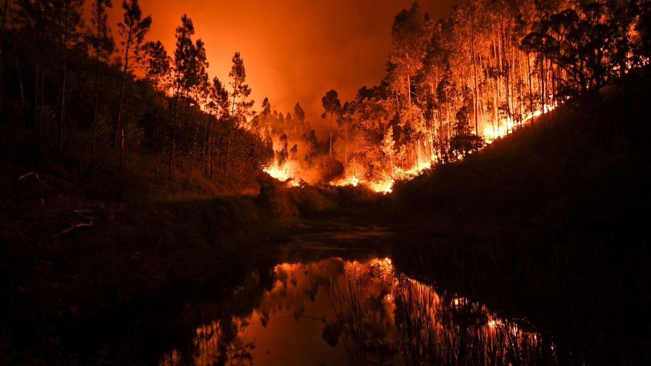 A massive wildfire is reflected in a stream in central Portugal on Sunday, June 18, 2017. Several hundred firefighters fought the blaze, which broke out Saturday in the municipality of Pedrogao Grande.  