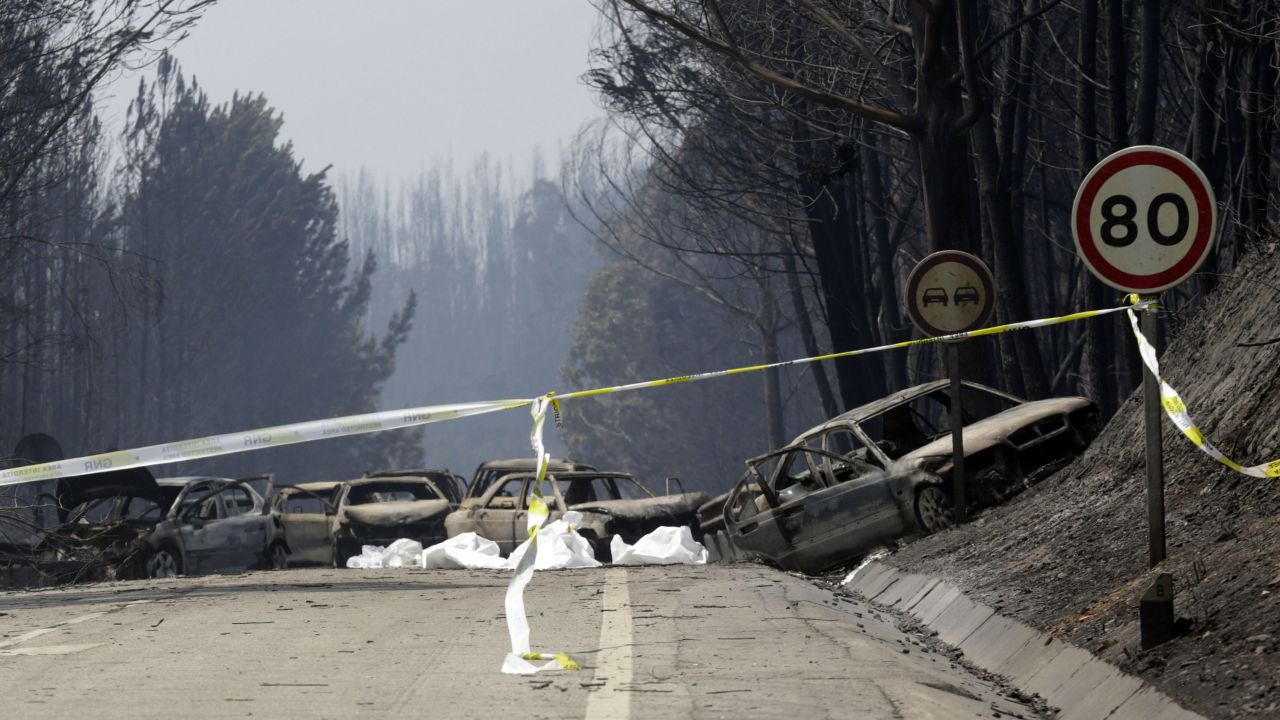 Burnt cars block the road between Castanheira de Pera and Figueiro dos Vinhos, central Portugal.