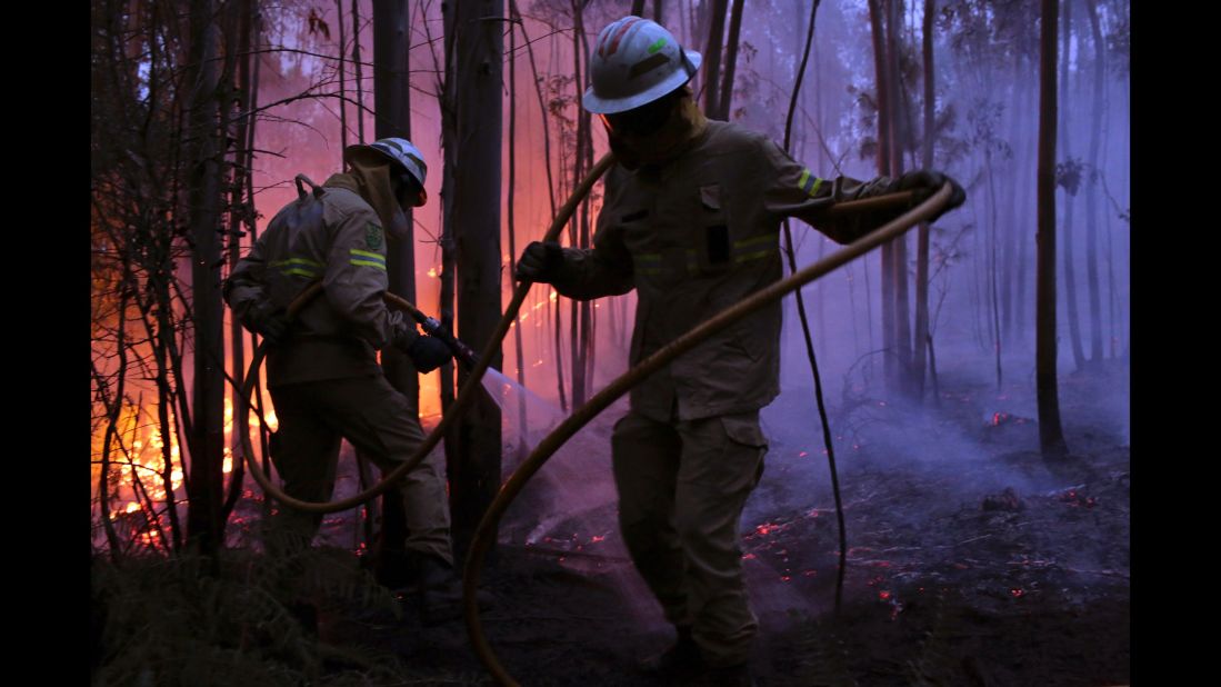 Portuguese National Republican Guard firefighters work to stop the fire from reaching the village of Avelar.