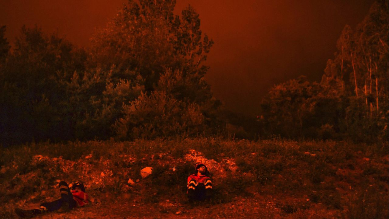 Firefighters rest after battling the wildfire in Penela, Coimbra, central Portugal.