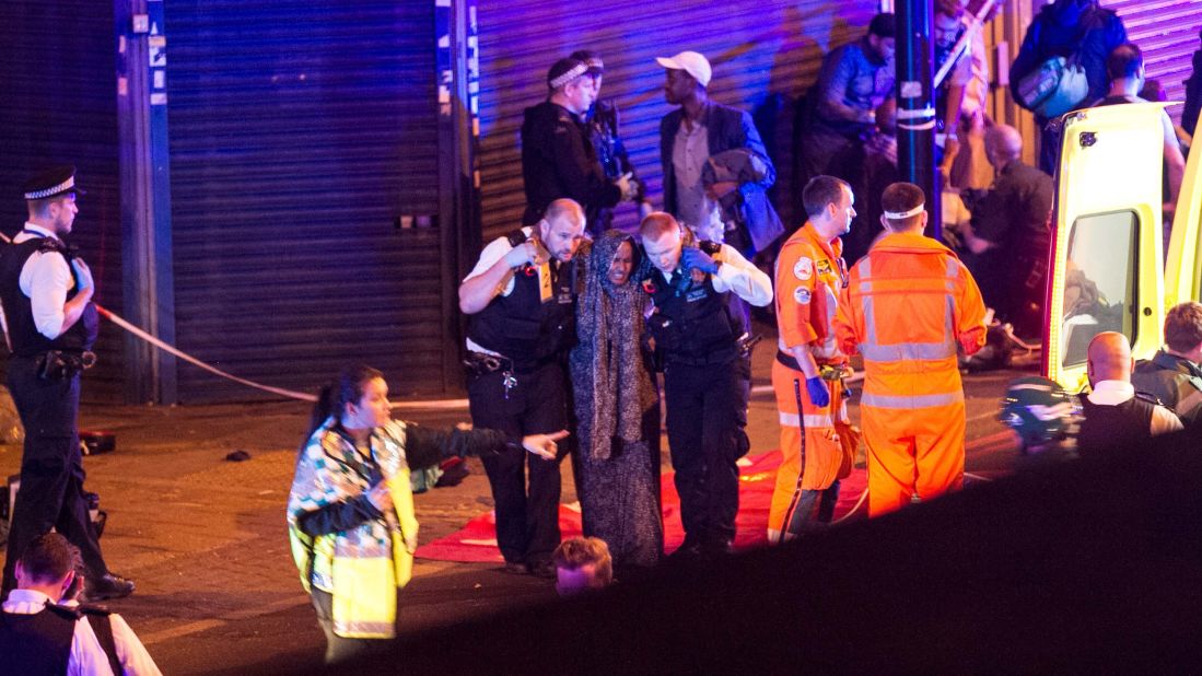 Police help a woman at the scene.