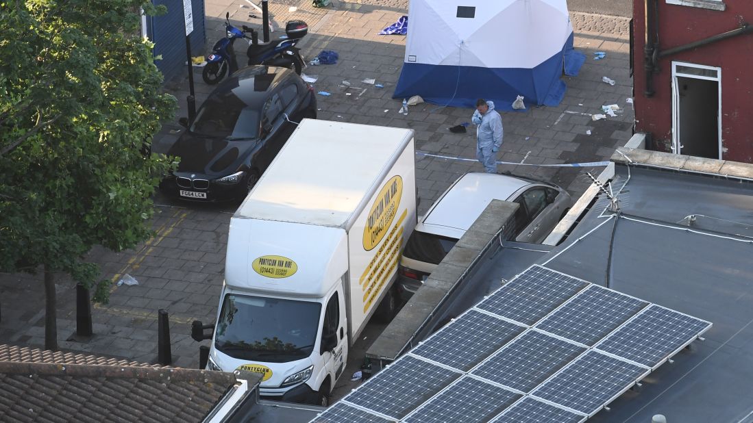 A forensics officer stands next to a van near the Finsbury Park Mosque.