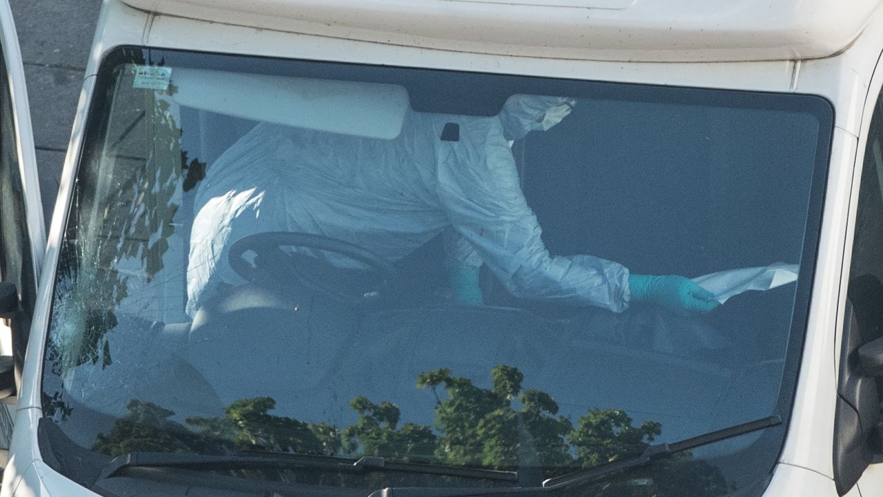 A forensics officer examines the interior of a van.