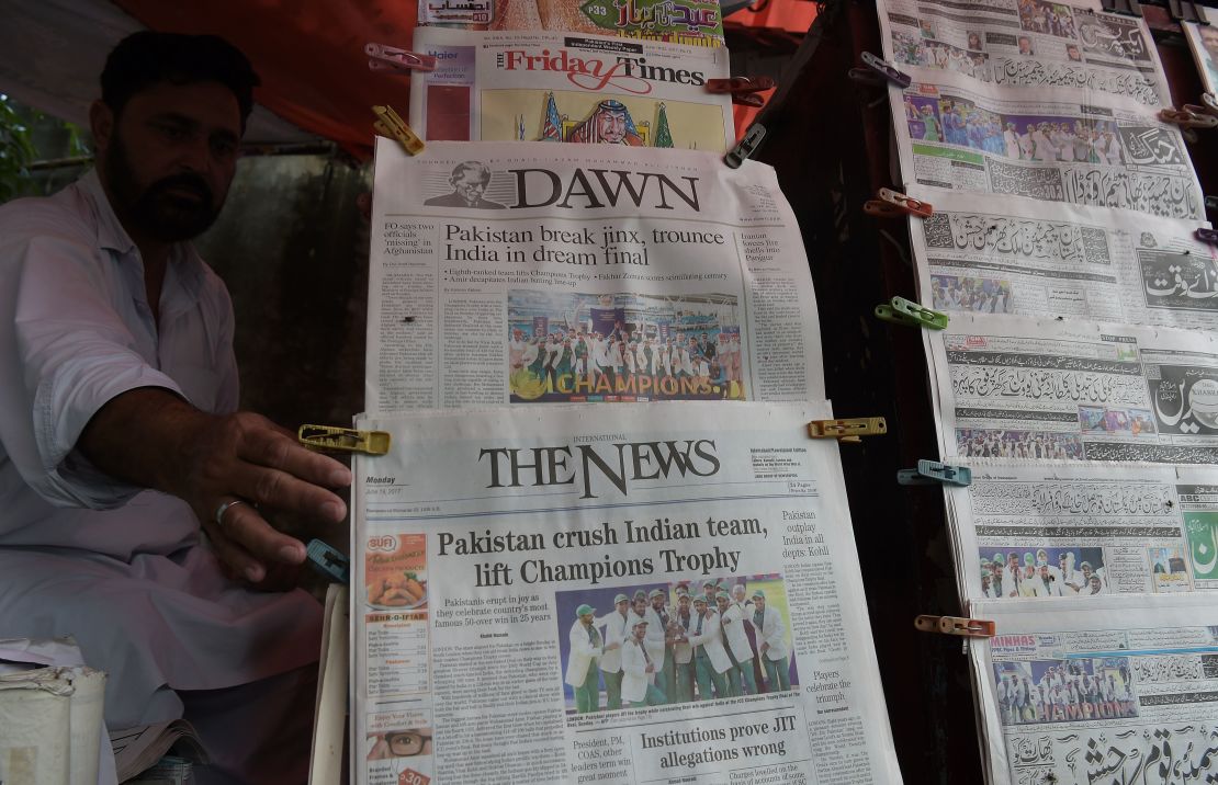 A Pakistani vendor arranges morning newspapers featuring front page coverage of Pakistan's victory against India in the ICC Champions Trophy final cricket match played in London, in Islamabad 