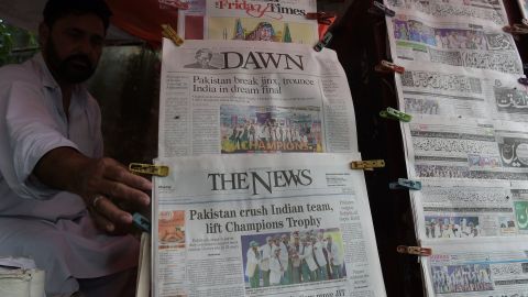 A Pakistani vendor arranges morning newspapers featuring front page coverage of Pakistan's victory against India in the ICC Champions Trophy final cricket match played in London, in Islamabad 