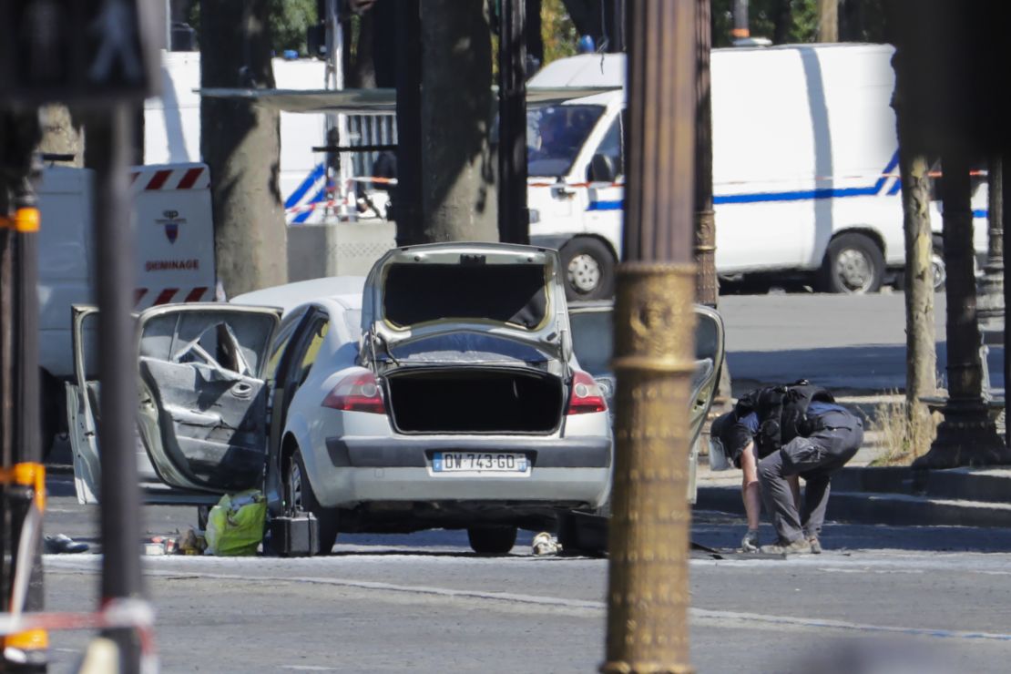 A bomb disposal police officer checks a car in a sealed off area on the Champs-Elysees avenue in Paris on Monday.