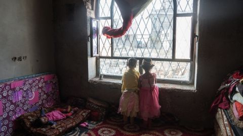 Children peer out of a window in a former government building in the suburbs of Ibb. The building was provided by local authorities to house 53 displaced families, but has no electricity or running water. 