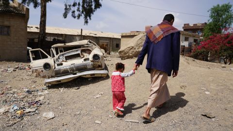 Abdellatif Allami walks with his three-year-old daughter Sara in the Harat Al-Masna'a slum in Sana'a, home to the families of former factory workers. They used to receive a basic pension of around $120 a month, but the payments stopped seven months ago, and the families now rely on donations to survive.