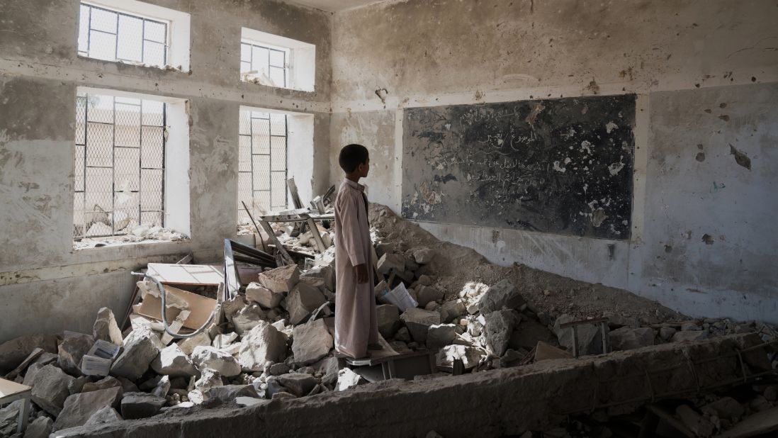 A student at the Aal Okab school stands in the ruins of one of his former classrooms. He and his fellow pupils now attend lesson in UNICEF tents nearby. 