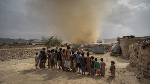 Children watch a mini tornado whip up sand as it travels across the desert near the town of Huth, 80km north of Sana'a. Aid agencies predict that by the end of the year, Yemen will be in a state of full-blown famine. 