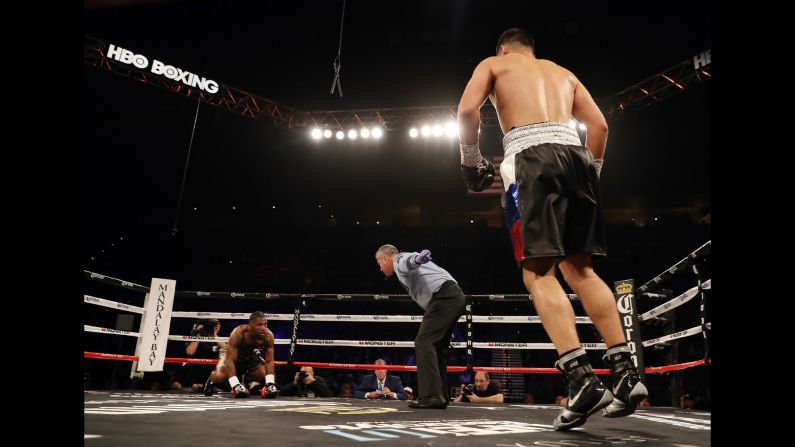Referee Russell Mora directs Dmitry Bivol to a corner as Cedric Agnew tries to get up from the canvas on Saturday, June 17. Bivol won the light-heavyweight bout with a fourth-round stoppage.