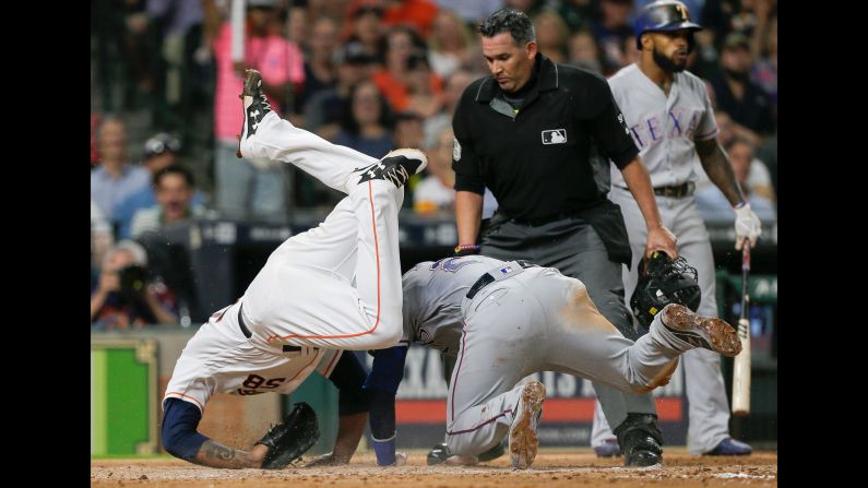 Houston pitcher Francis Martes, left, tumbles over Texas' Jonathan Lucroy as Lucroy scores on a wild pitch on Wednesday, June 14.