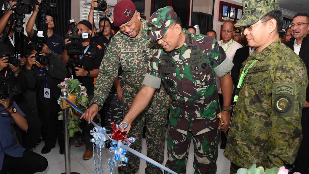 Officers of the Indonesian, Malaysian and Philippines militaries cut a ribbon at a ceremony announcing new joint patrols by the three countries.