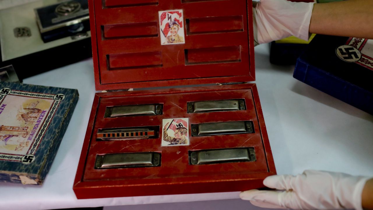 A member of the federal police shows a box containing harmonicas.