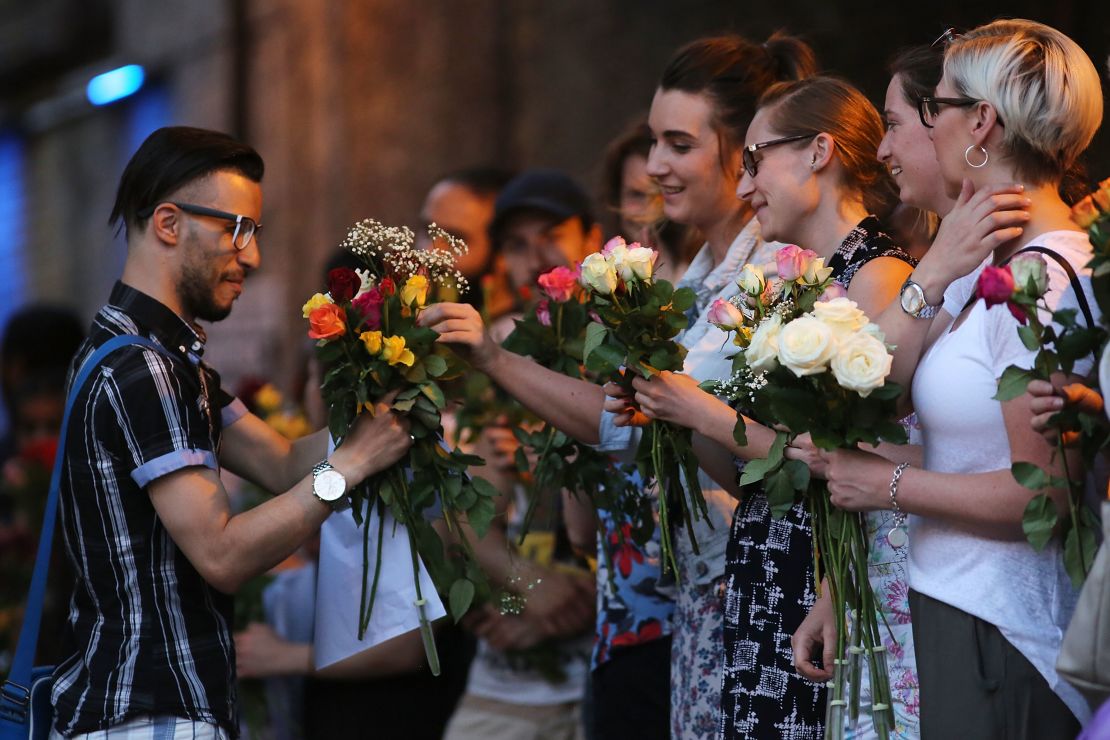 Women hand out flowers at a vigil outside Finsbury Park Mosque on Monday.