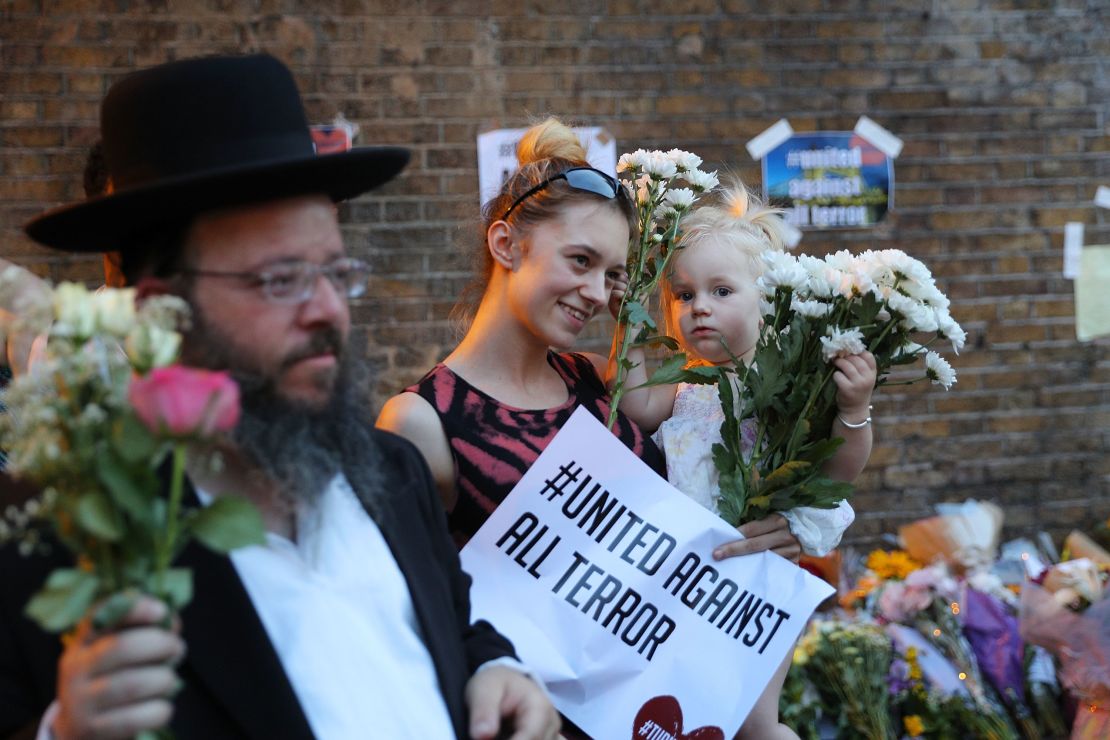 A woman holds up a sign saying 'united against terror' at the vigil.