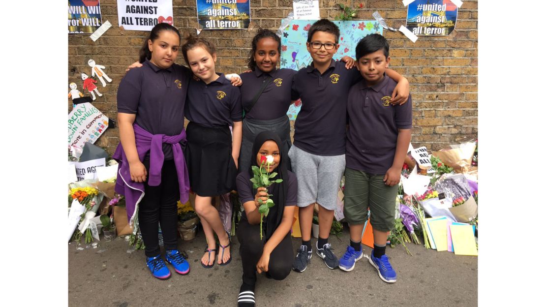 A group of school children visit the makeshift memorial on Tuesday.