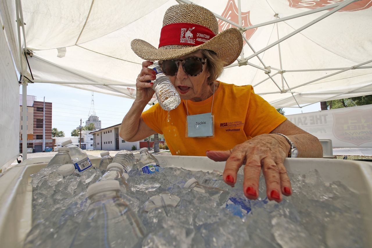 Volunteer Jackie Rifkin tries to keep cool June 19 at she works at a Salvation Army station to help people stay hydrated in Phoenix.