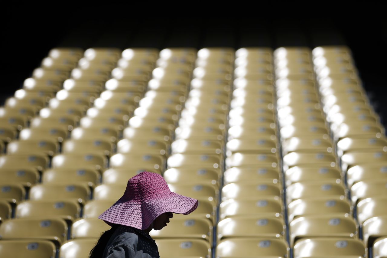 A worker wears a large hat, wet with water, while cleaning seats at Los Angeles' Dodger Stadium on June 19.