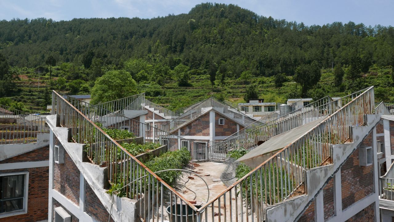 The new houses in Jintai Village, designed by RUF, feature stepped roofs. With limited land available to villagers, the inverted roofs give residents extra space to grow crops.