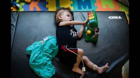 Anias plays with a toy while laying on a mat in his room at Blythedale Children's Hospital.