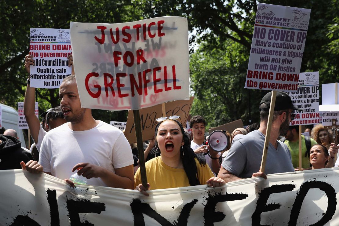 Protesters hold signs calling for justice for the victims of the Grenfell disaster during an anti-government protest on Wednesday.