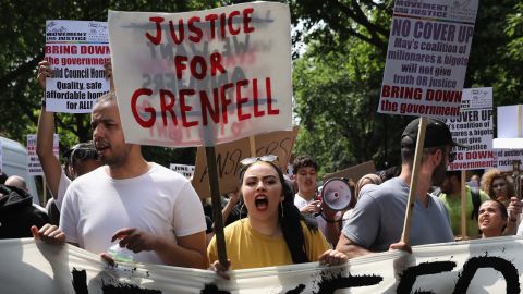 Protesters hold signs calling for justice for the victims of the Grenfell disaster during an anti-government protest on Wednesday.