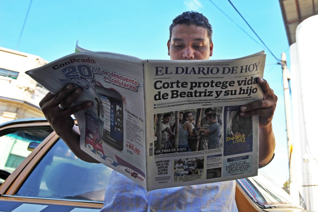 A man reads a paper headlined: "Court protects life of Beatriz and child." Beatriz, a chronically ill Salvadoran woman was denied an abortion in 2013, despite the fact her fetus was unviable.