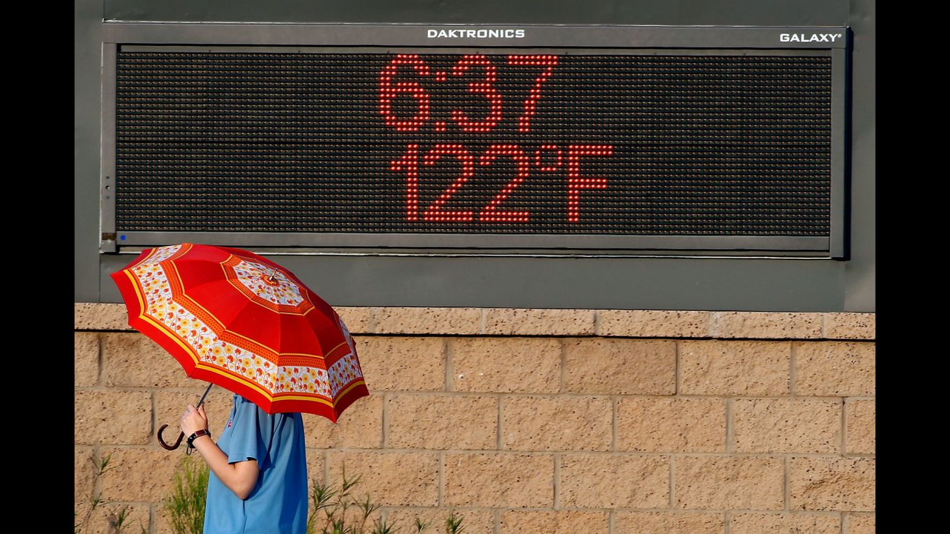A pedestrian in Phoenix uses an umbrella to get some relief from the sun on June 20.