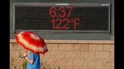 PHOENIX, AZ - JUNE 20:  A pedestrian uses an umbrella to get some relief from the sun as she walks past a sign displaying the temperature on June 20, 2017 in Phoenix, Arizona.  Record temperatures of 118 to 120 degrees were expected on Tuesday for the Phoenix-metro area.  (Photo by Ralph Freso/Getty Images)