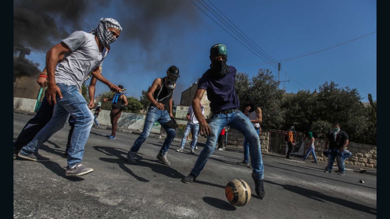 Taken in October 2016, this is a picture of masked Palestinian youths playing football at the main entrance of the West Bank city of Bethlehem.
