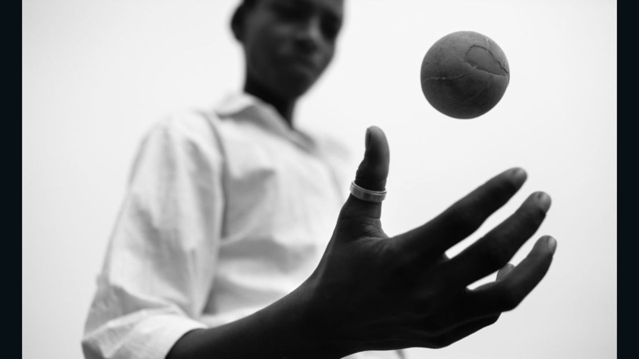 This photo is part of a project created by David Jimenez titled "Omen." Here a young boy in India plays with a worn cricket ball.