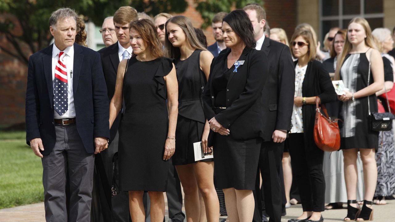 Fred and Cindy Warmbier, left and center, watch as the casket of their son is carried out of his funeral.